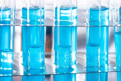 Close-up of blue liquid in test tubes for chemistry experiments in a laboratory setting.